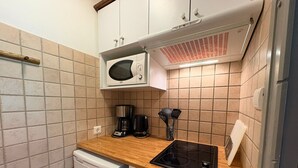 A compact kitchen with a microwave, coffee maker, and a small oven.