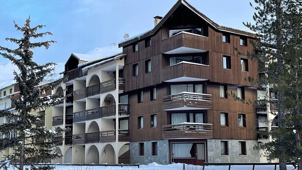 A multi-story hotel with balconies and a stone facade. - Cozy studio with slopes access, shuttle and parking. For 4 guests. (La Salle-les-Alpes)
