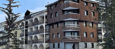 A multi-story hotel with balconies and a stone facade.