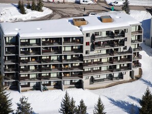 A multi-story hotel with balconies, located in a snowy area. - Bright apartment in center with balcony and parking (Flaine)