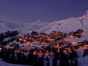 A snow-covered mountain resort with multiple lodge buildings, ski lifts, and a clear view of the surrounding snowy landscape. - Studio on the slopes pets allowed (Belle Plagne)