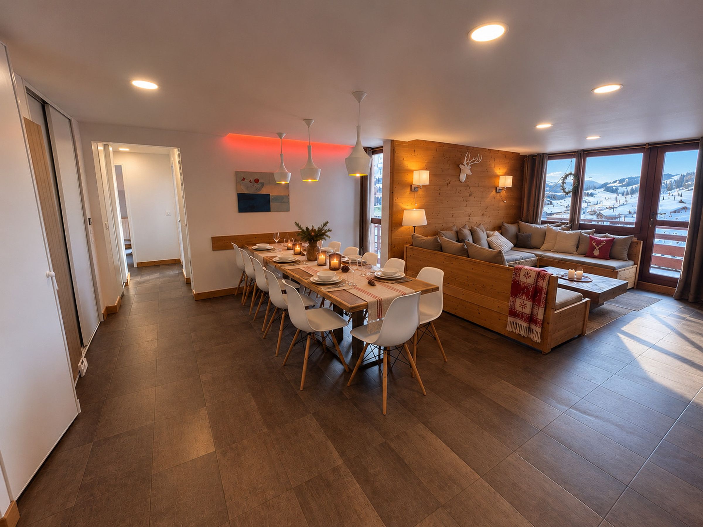 Un intérieur moderne comprenant un coin repas, un canapé et de grandes fenêtres.