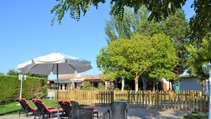 Un patio al aire libre con sillones de descanso y una sombrilla grande.