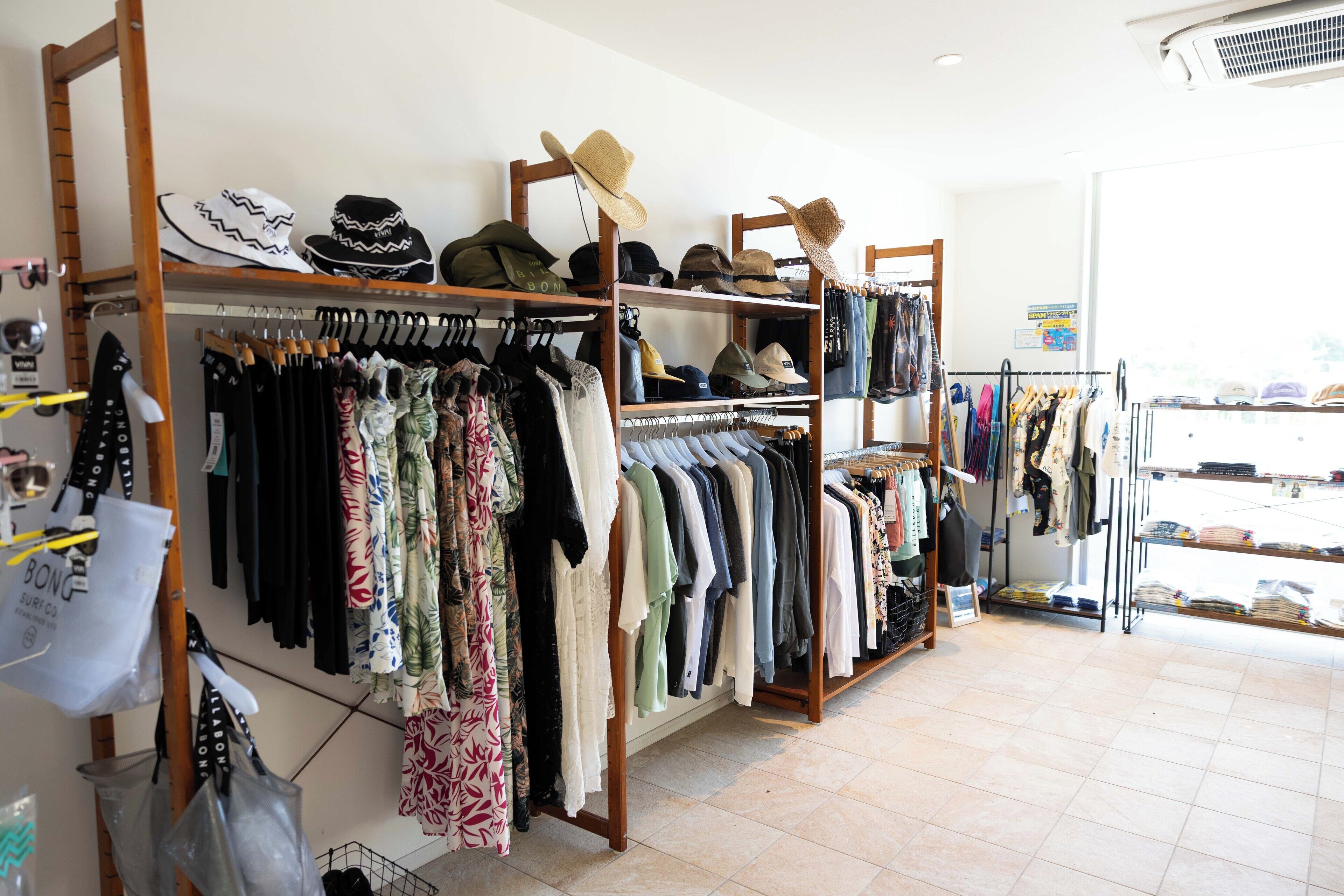 Un magasin de vêtements où l’on trouve des étagères remplies de vêtements et de chapeaux.