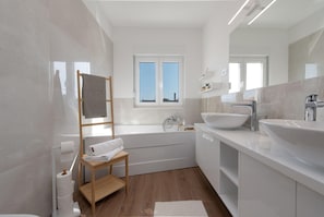 A modern bathroom with a bathtub, two sinks, a large mirror, and a window. - Villa Dora Zadarvillas (Policnik)
