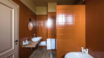 A modern bathroom with a wooden vanity, a large bathtub, and orange-tiled walls.