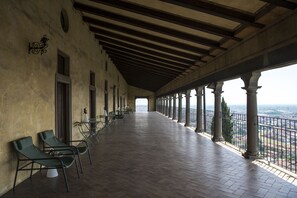 A covered outdoor area with a tiled floor, columns, and a railing overlooking a cityscape. - L'Annunciata Soul Retreat (Rovato)