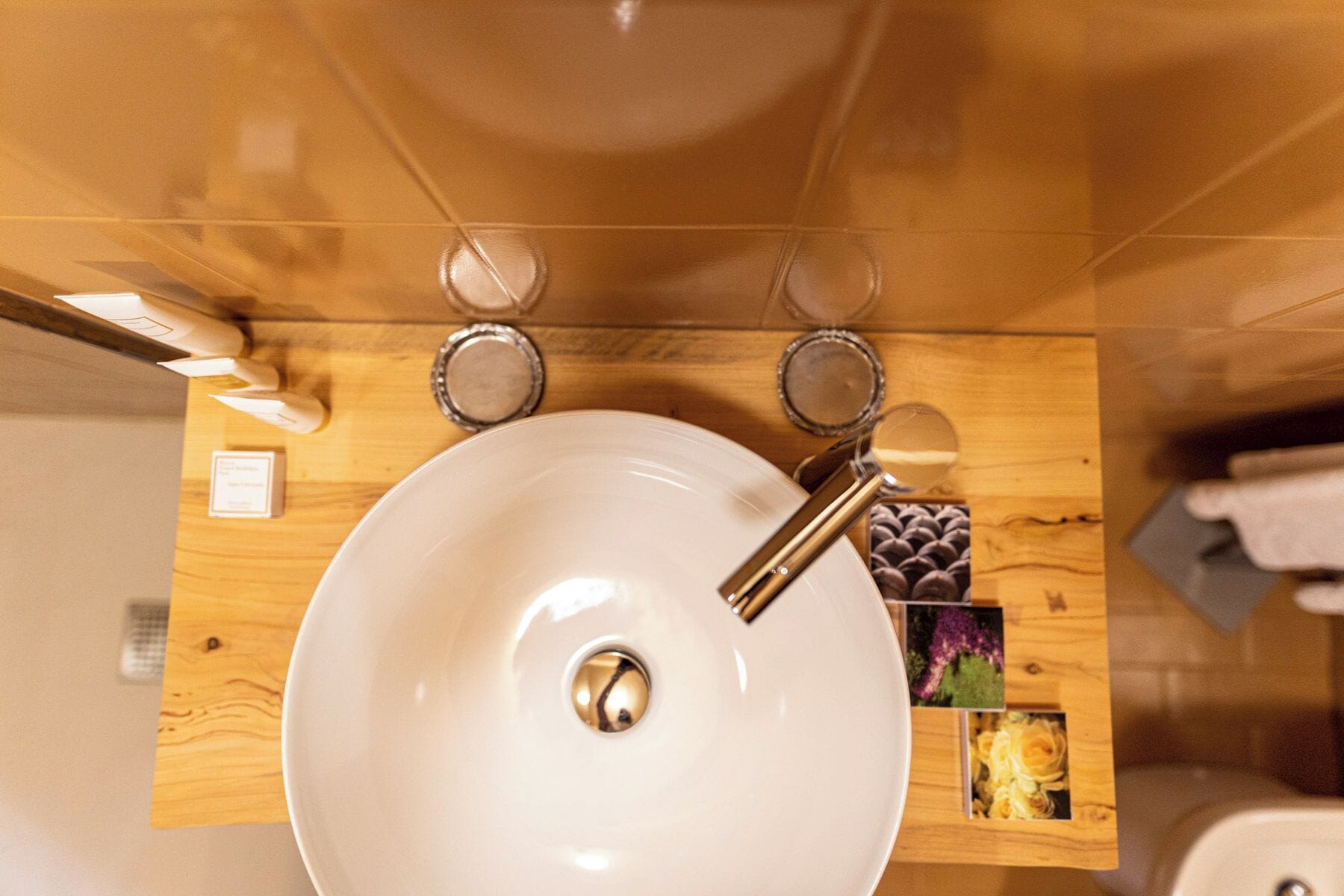 Un baño con un lavamanos blanco, tocador de madera y un espejo.
