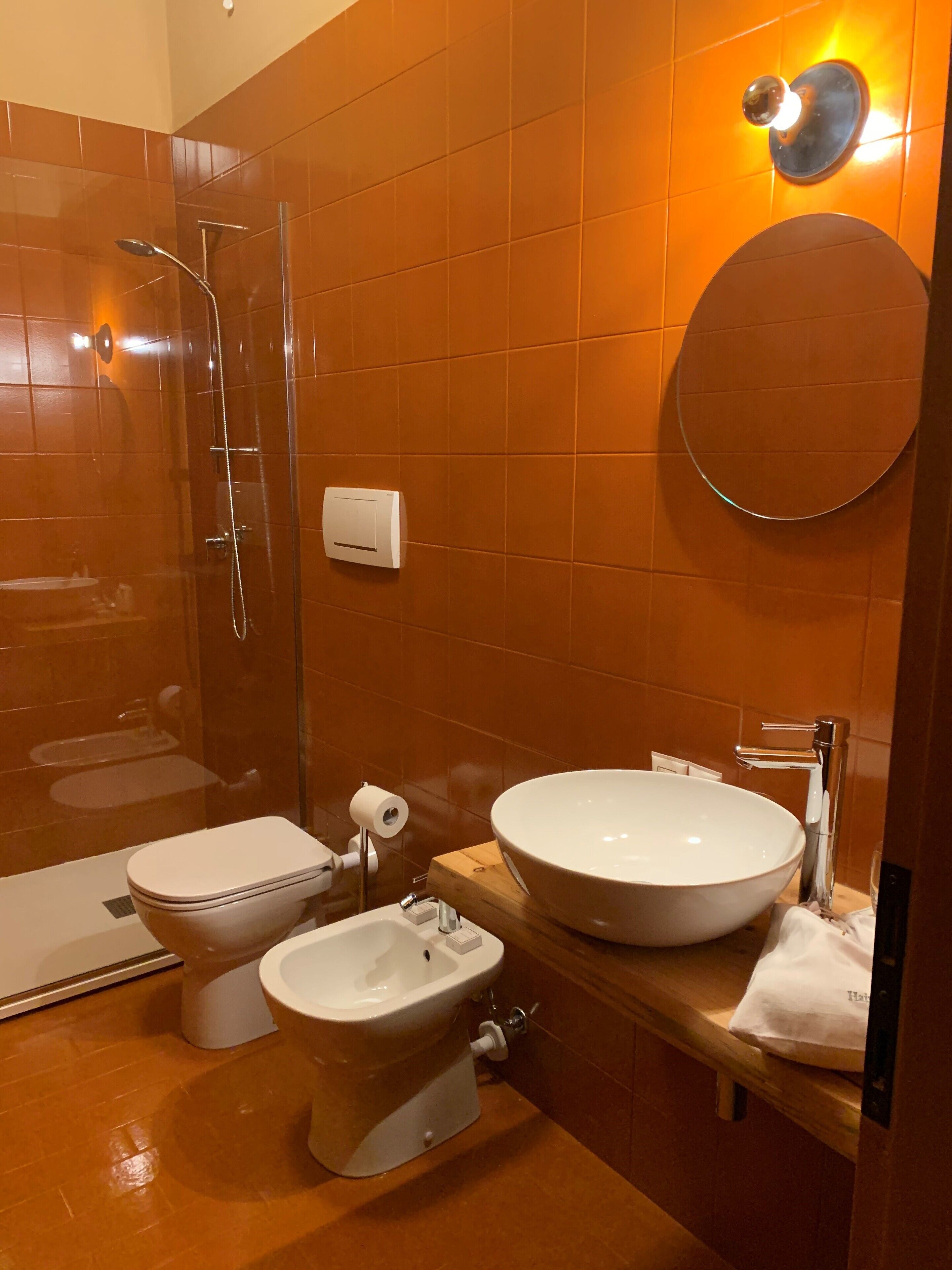 Ein modernes Badezimmer mit einer Duschkabine, einer Toilette, einem Bidet und einem großzügigen Waschbecken.