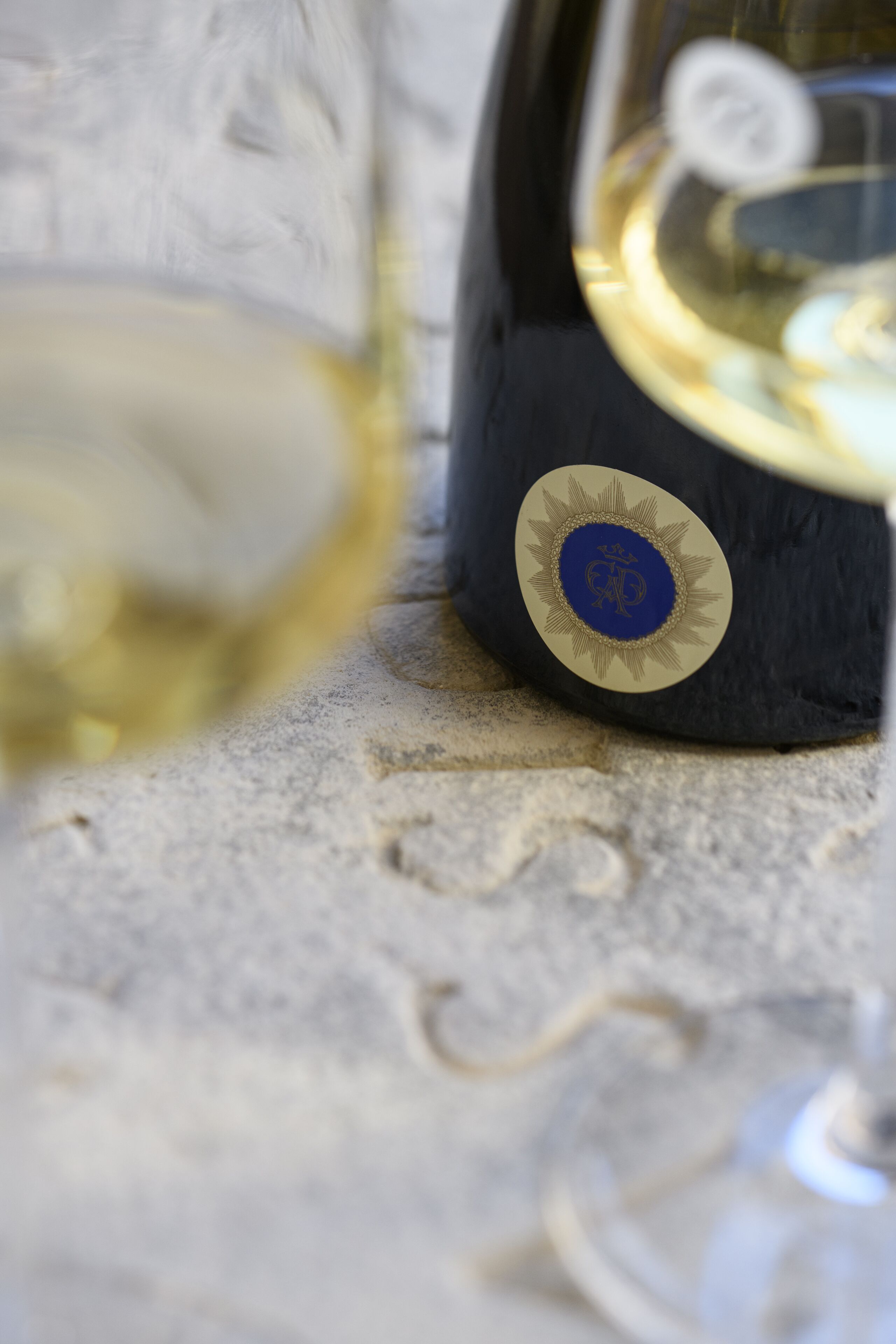 A bottle with a blue and gold emblem on a textured surface.