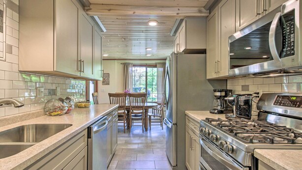 Een moderne keuken met roestvrijstalen apparatuur, een centraal eiland en een eetgedeelte met uitzicht.