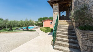 A stone building with a stone staircase leading to a covered entrance. - Pool, whirlpool, 12 persons, garden, children's playground,bicycles,table tennis (Anžici)