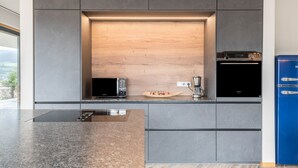 Una cocina moderna con microondas integrado, cafetera y refrigerador azul.