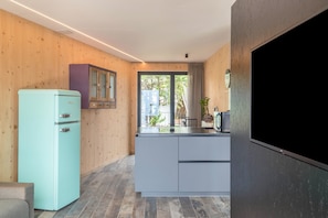 A modern kitchen with a teal refrigerator, white cabinets, and a large window. - 'AUMIA Apartment Turmalin' with Mountain View & Terrace (Völs)