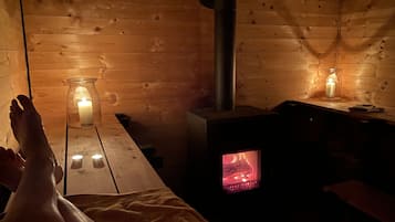 Cozy cabin interior with a central wood-burning stove and rustic design.