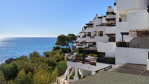 Zona residencial costera con edificios blancos, balcones y vistas al mar.