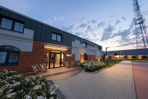 Un bâtiment moderne avec une façade en briques, de grandes fenêtres et une entrée bien éclairée.