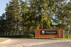 Une enseigne pour l’hôtel IGNASIAK, avec un logo, indiquant qu’il propose des services d’hôtellerie, d’organisation d’événements et de sports.