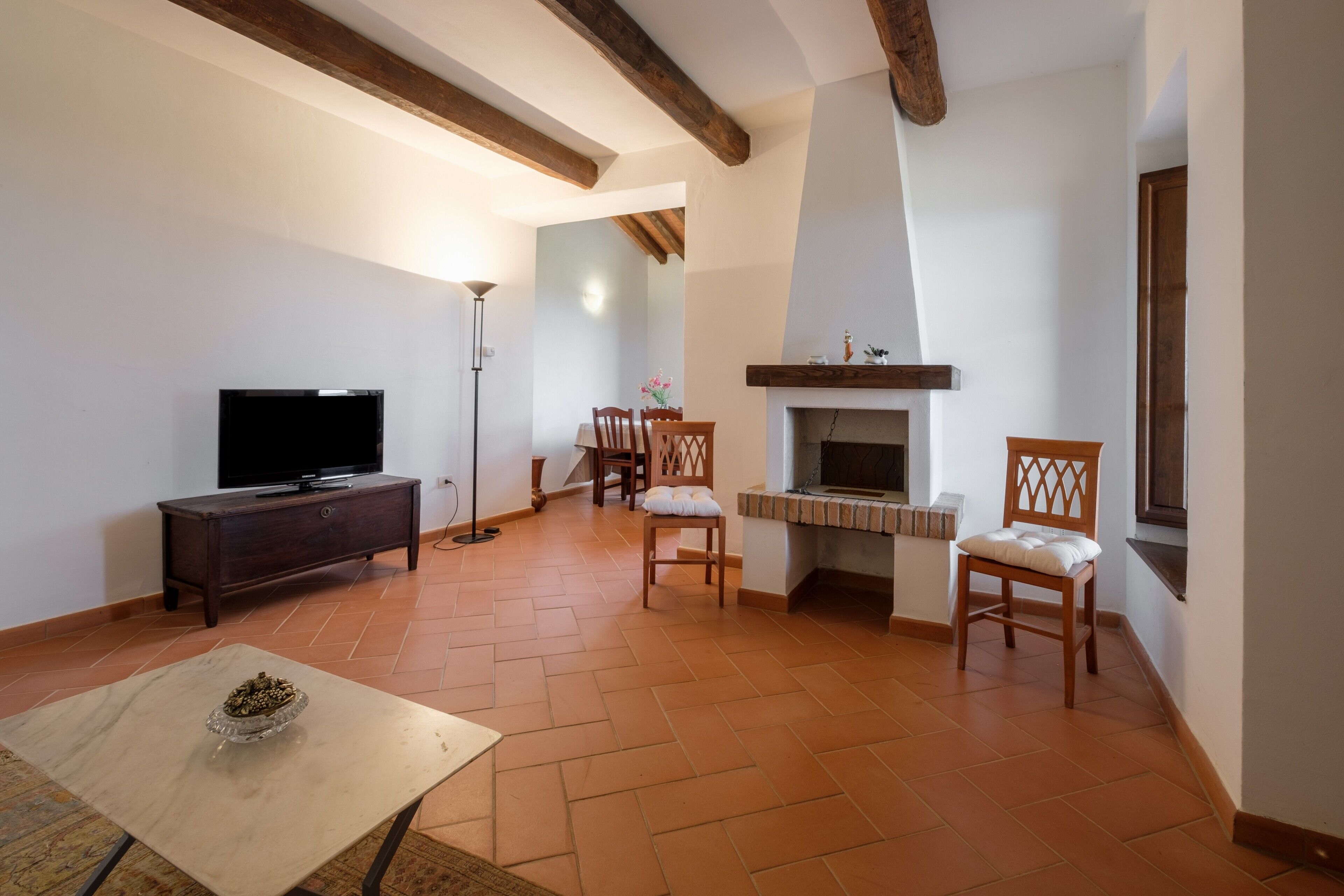 Una sala de estar con chimenea, televisor y comedor.