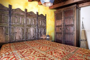 A room with a large bed, a wooden wardrobe, and a decorative lantern.