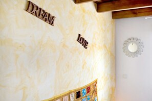Ein Zimmer mit einer Marmorwand, Holzbuchstaben, die 'DREAM LOVE' bilden, und einem dekorativen Spiegel.