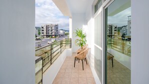A balcony with a view of a cityscape, a potted plant, and two wicker chairs. - Pet Friendly Taitung Chun Yang Smart Stay (Taitung)