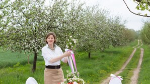 A woman arranging a table with a bouquet of flowers and a ribbon. - Uckermark-Im Gutshaus vacation apartment (Boitzenburger Land)