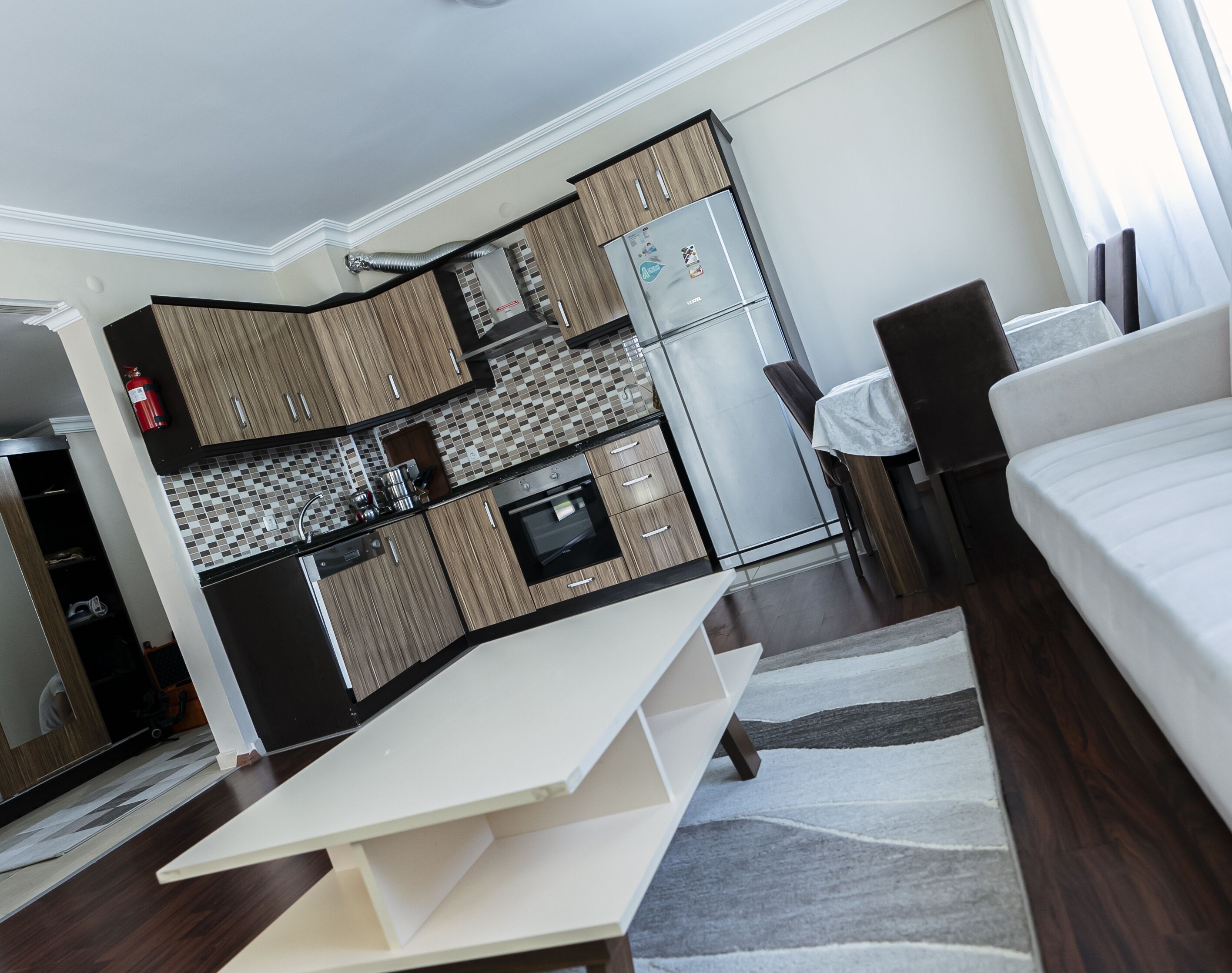 Une chambre d’hôtel compacte comprenant un coin cuisine, un lit, un espace salon et une vue sur l’extérieur.