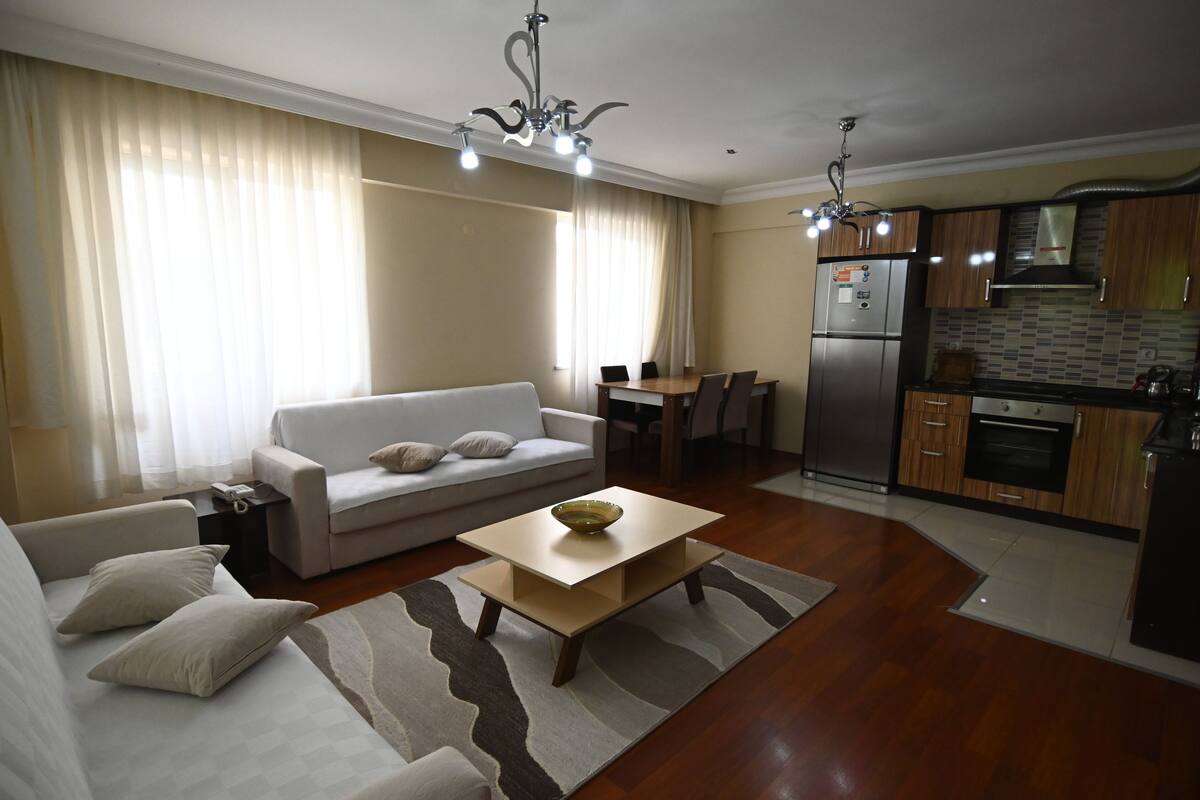 Un salon moderne avec un canapé, une table basse et un coin repas.