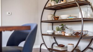 Una estantería metálica escalonada con varios objetos decorativos y libros.