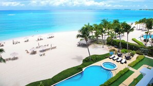 Un resort con piscina, playa y palmeras.