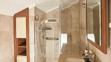 Un baño moderno con ducha de vidrio, lavamanos y retrete.