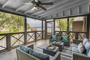A covered outdoor seating area with wicker furniture and a ceiling fan. - Chalet Premiere at Signal Point (Guntersville)