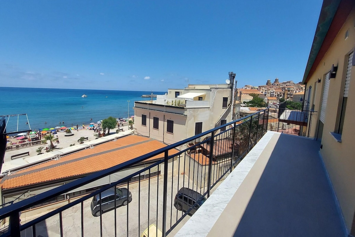 Un balcon avec vue sur une plage et la mer.
