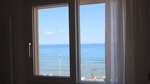 Una habitación con un ventanal que da a la playa.