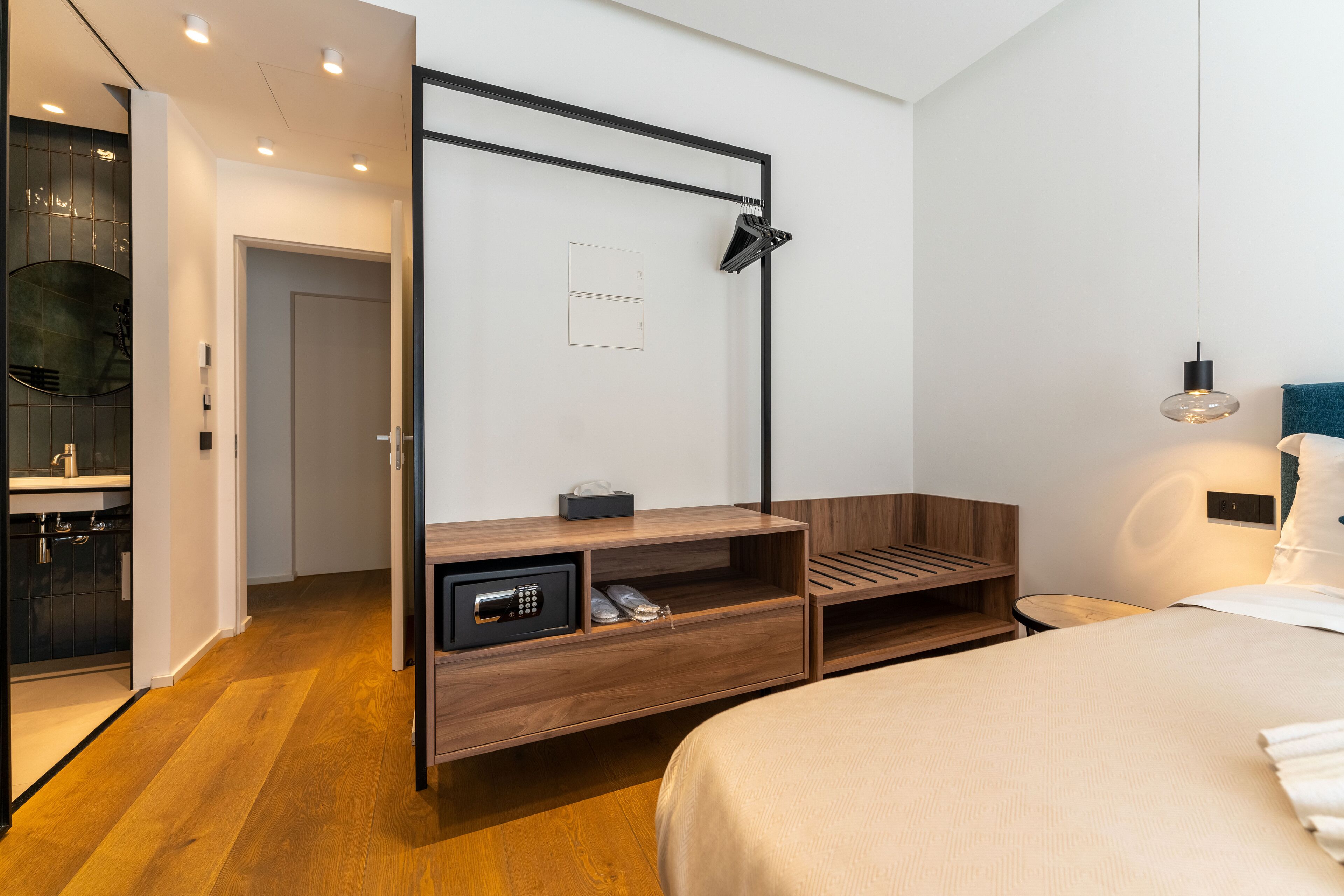 Een moderne hotelkamer met een houten bed, een ingebouwd bureau, een magnetron en een klein zitgedeelte.
