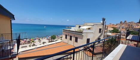 A balcony with a view of a beach and cityscape.