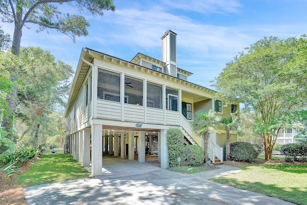A two-story house with a covered porch, a chimney, and a well-maintained lawn.