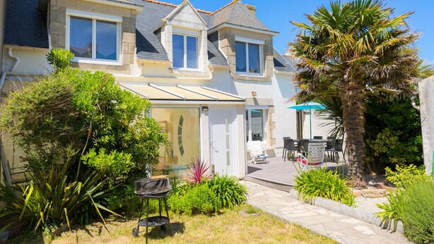 A two-story house with a balcony, a patio with outdoor furniture, and a variety of plants. - Holidays for 6 in Saint Guénolé (Penmarch)