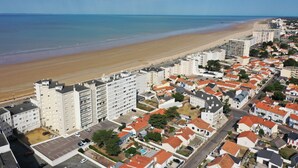 Una zona residenziale costiera con edifici a più piani, una spiaggia e cielo sereno.