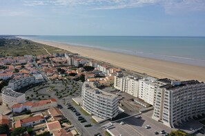 Une ville côtière dotée d’une plage, de bâtiments modernes et d’un parking.