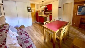 Um espaço compacto com cozinha compacta, área de refeições e uma cama.