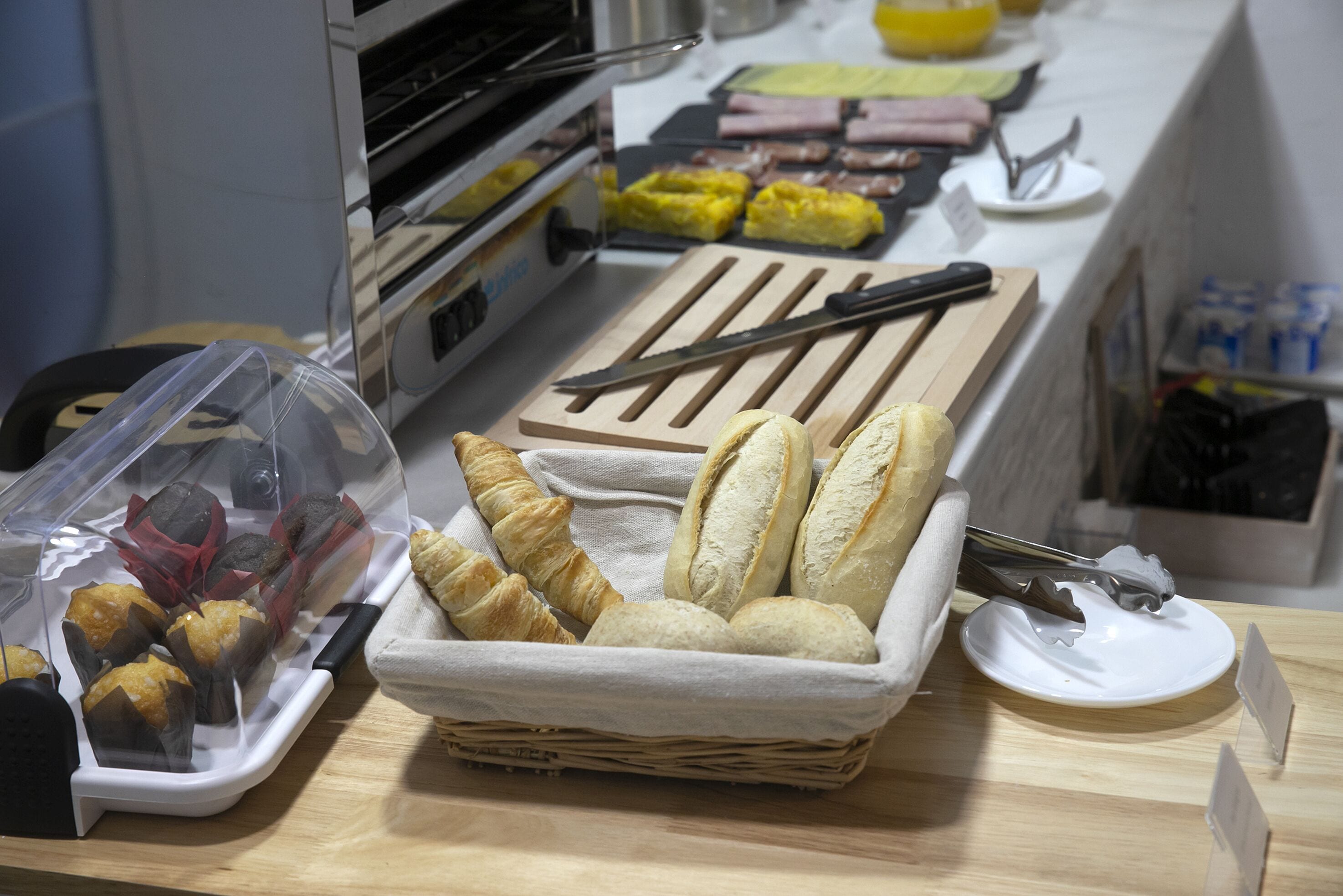 Een aanrecht met diverse gebakken producten, zoals brood en gebak, en keukengerei.