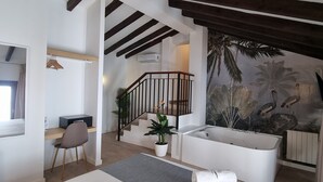 Un baño moderno con bañera, ducha y un mural tropical.