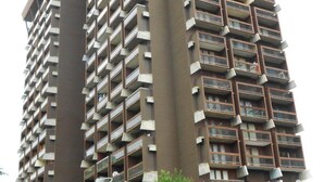 Un edificio residencial alto con varios balcones y una estructura central.