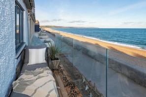 Un balcón con vista a la playa y al océano.