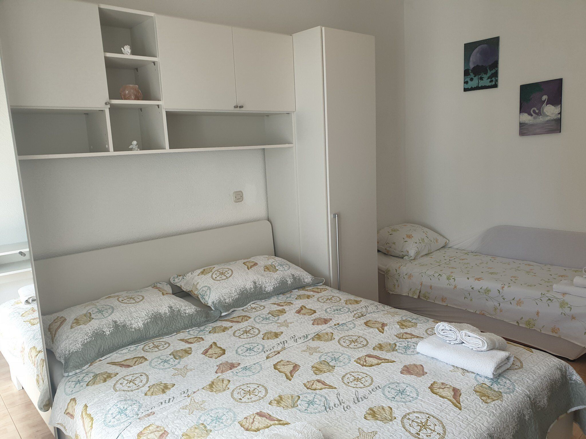 Une chambre à coucher avec un lit, un petit bureau et une armoire.