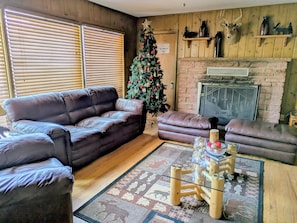 Uma sala de estar aconchegante com um sofá de couro marrom, uma mesa de centro de madeira e um pinheiro de Natal.