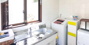 Una cocina compacta con un lavamanos, un refrigerador y una ventana.