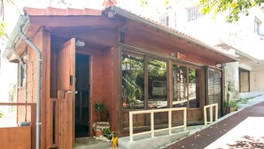 A wooden building with a sign reading "Guest House Warayun-se" and a large window.